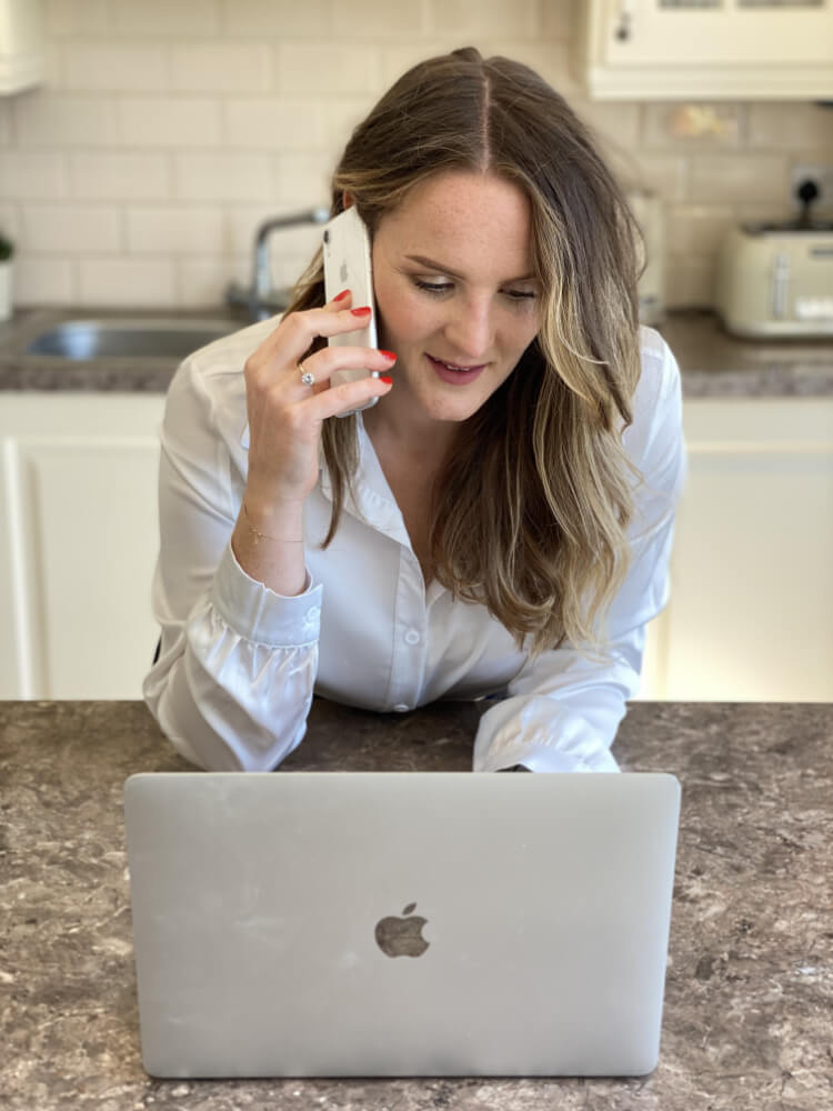 Marta Holewa, a nutritionist, talking on the phone while using a laptop.